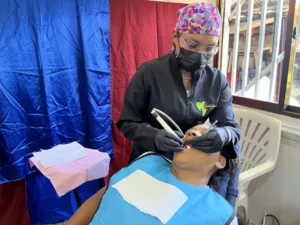 Dra Tibisay Gudiño Aray realizando una limpieza dental